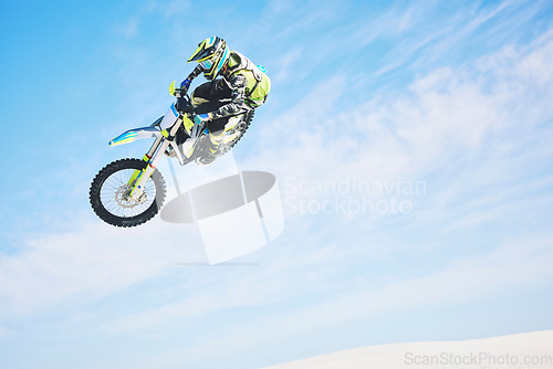 Image of Motorbike, jump and person in the air with blue sky, mock up and stunt in sports with fearless person in danger with freedom. Motorcycle, jumping and athlete training for challenge or competition