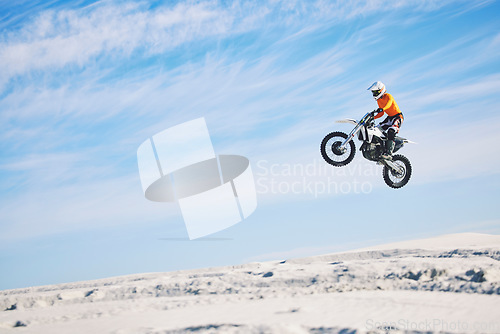 Image of Motorcycle, desert and jump for sports in race, adrenaline and training for fitness in competition. Athlete, sky and mockup for freedom, driving and dirtbike in outdoor for stunt or performance