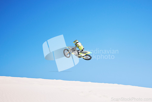 Image of Motorbike, jump and man in the air with blue sky, mock up and stunt in sports with fearless person in danger with freedom. Motorcycle, jumping and athlete training for challenge or competition