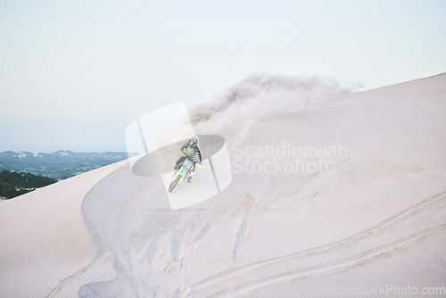 Image of Motorcycle, desert and race for sports in sand, adrenaline and training for fitness in competition. Athlete, sky and mockup for extreme sport, driving and dirtbike in outdoor for stunt or performance