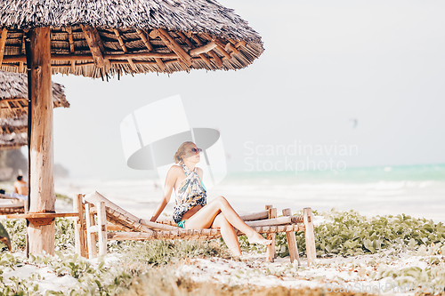 Image of Woman sunbathing on tropical beach.