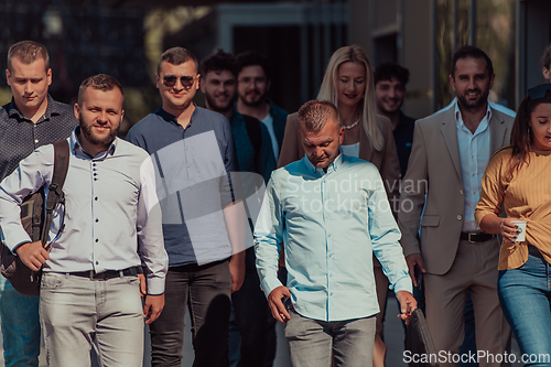 Image of A diverse group of businessmen and colleagues walking together by their workplace, showcasing collaboration and teamwork in the company.