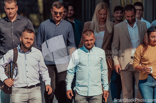 Image of A diverse group of businessmen and colleagues walking together by their workplace, showcasing collaboration and teamwork in the company.