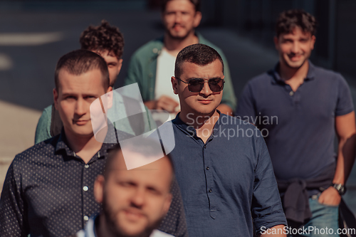 Image of A diverse group of businessmen and colleagues walking together by their workplace, showcasing collaboration and teamwork in the company.