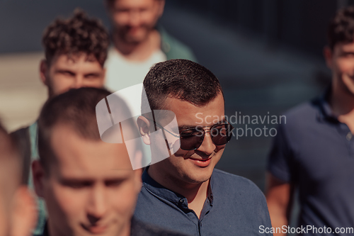 Image of A diverse group of businessmen and colleagues walking together by their workplace, showcasing collaboration and teamwork in the company.