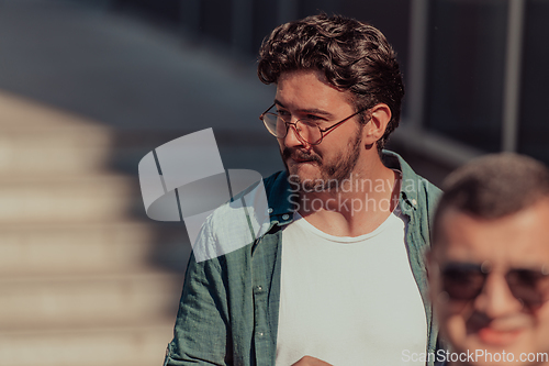 Image of A diverse group of businessmen and colleagues walking together by their workplace, showcasing collaboration and teamwork in the company.