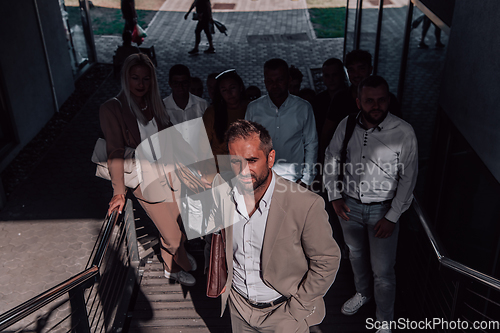 Image of A diverse group of businessmen and colleagues walking together by their workplace, showcasing collaboration and teamwork in the company.