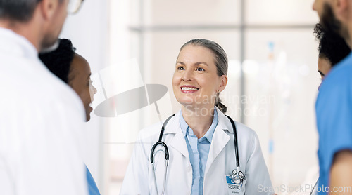 Image of Mature woman, doctor and team planning with smile, leadership and mentor to interns at hospital. Happy medical professional, support and teaching students on healthcare, wellness and treatment