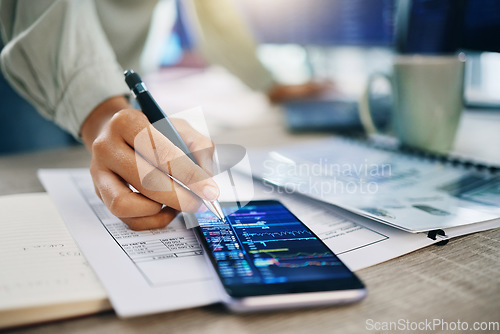 Image of Phone screen, hand and trading, dashboard and financial information with investment, paperwork and trader in office. Person at desk, stock market stats and finance, closeup of analysis and crypto