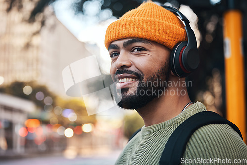 Image of Smile, music headphones and man in city outdoor, listening to audio or sound track on internet to travel. Radio, streaming podcast and happy person hearing media online, freedom or thinking in street