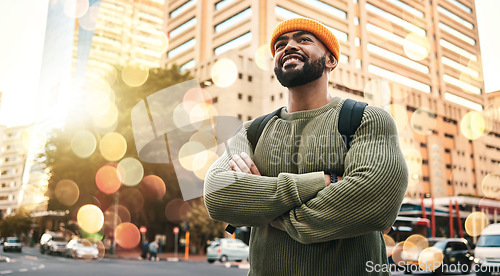 Image of Happy, man and student with arms crossed in city to travel or commute to university in urban, cbd or town campus. College, person and confident outdoor with smile or relax in street with buildings