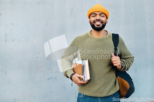 Image of Student, portrait and backpack for education, learning and smile for university or college on a wall background. Happy young, african man with books, bag and ready for scholarship, study or research