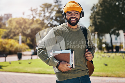 Image of Student, headphones and backpack on campus of education, college or university podcast in park. Portrait of african man walking, travel and books with audio, electronics or listening to music outdoor