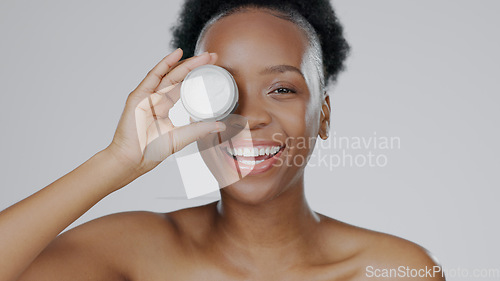 Image of Happy black woman, portrait and face cream for skincare, beauty or cosmetics against a studio background. African female person or model smile with moisturizer, creme or lotion for facial treatment