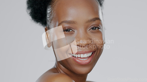 Image of Portrait, skincare and smile with a happy black woman in studio on a gray background for natural wellness. Face, beauty and aesthetic with a happy young model closeup for antiaging skin treatment