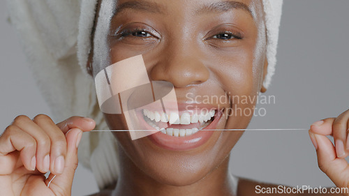 Image of Portrait, black woman with floss for teeth and dental, health and wellness with beauty on grey background. Oral hygiene, orthodontics and clean plaque away with smile and morning routine in studio