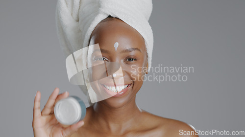 Image of Woman, moisturizer and smile in portrait for skincare or beauty, health and wellness or dermatology. Happy black person, skin and cosmetics with glow, care and cream in studio by gray background