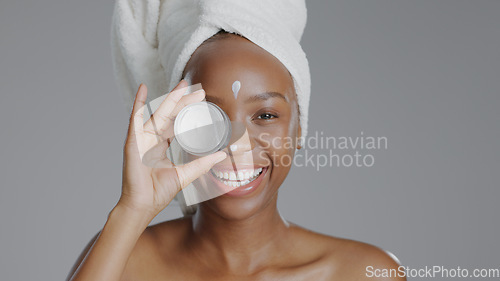 Image of Woman, moisturizer and smile in portrait for skincare or beauty, health and wellness or dermatology. Happy black person, skin and cosmetics with glow, care and lotion in studio by gray background