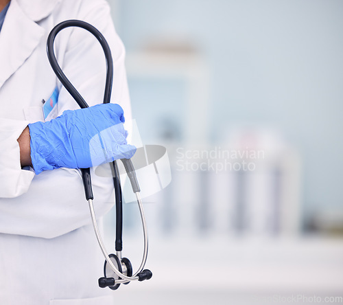 Image of Doctor, hand and stethoscope of professional with arms crossed for medical or healthcare at hospital. Closeup of nurse or surgeon holding tool or equipment in cardiology, health or wellness at clinic
