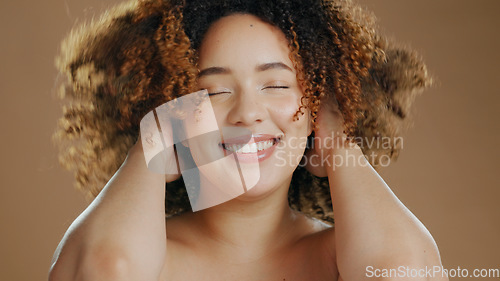 Image of Happy woman, curly hair or natural beauty dermatology for wellness in studio with smile or skin glow. Face, smile or confident biracial female person with skincare cosmetics on a brown background