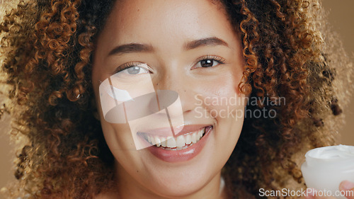 Image of Black woman, skincare and cream on face for dermatology, beauty or happiness on brown background in studio. Skin, care or happy portrait with cosmetics, lotion or sunscreen for facial wellness