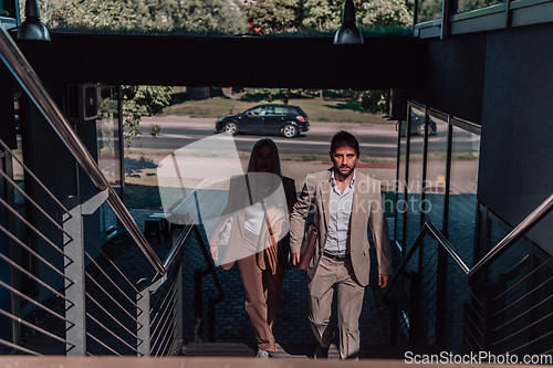 Image of Modern business couple after a long day's work, walking together towards the comfort of their home, embodying the perfect blend of professional success and personal contentment.