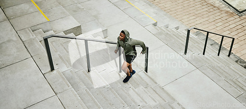 Image of Fitness, city and black man running on stairs outdoor, exercise and training healthy body in urban town top view. Sports, cardio and African athlete on steps for workout, energy and jog for wellness