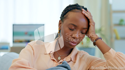 Image of Sad, worry and black woman on couch with a problem, crisis and ideas of stress in a home living room or lounge. Fear, house and person scared and anxious about a mistake, fail or unhappy on a sofa