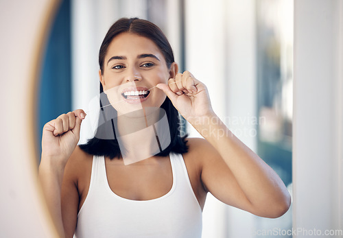 Image of Dental floss, teeth and woman in mirror of bathroom for oral hygiene, morning routine or gum health. Beauty, wellness and self care with girl and big smile in reflection for cleaning tooth and mouth