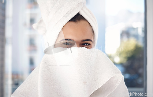Image of Portrait, towel and woman after a shower, happy and relax while hiding face and grooming in her home. Shy, girl and beauty, skincare and routine in bathroom for cleaning, hygiene and fun in New York