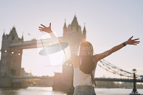 Image of Woman, freedom and travel by the London bridge or city for holiday break or outdoor summer vacation. Joyful female tourist with open arms enjoying sunny adventure trip, traveling and sightseeing