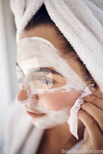 Image of Facial, skincare and woman peeling a face mask for beauty in a grooming treatment with dermatology products. Relaxed, cream and young girl with tissue to wipe acne lotion cosmetics in a bathroom