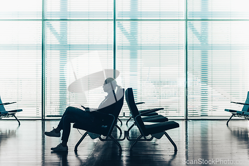 Image of Woman in transit waiting on airport gate.