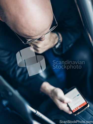 Image of Businessman using his cell phones on subway.