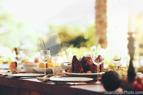 Image of Food, table and traditional celebration on a patio with no people for thanksgiving, party and a fun gathering setup for family at home. Turkey, chicken and dining table ready for family lunch outdoor