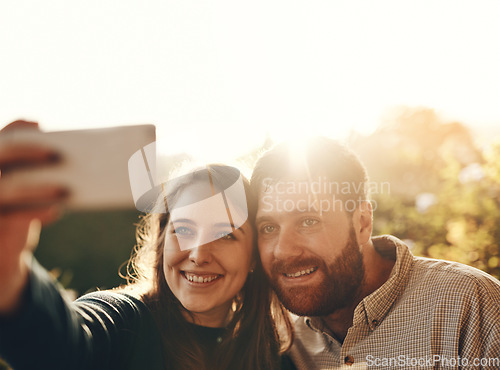 Image of Selfie, smile and couple in nature with a phone for social media, memory and happiness. Flare, happy and young man and woman with a photo on a mobile while on a date in a park for love in marriage