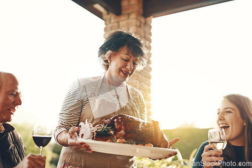 Image of Woman, roasted chicken, turkey and food outdoor at dinner table, thanksgiving cooking and family lunch, meal and social gathering together. Happy lady hosting celebration, meat plate and party feast