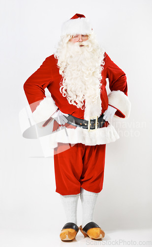 Image of Santa claus, wink and man in costume in a studio for christmas, fun and hands on hip against a white background mockup. Santa, senior man and emoji portrait by playful male in festive celebration