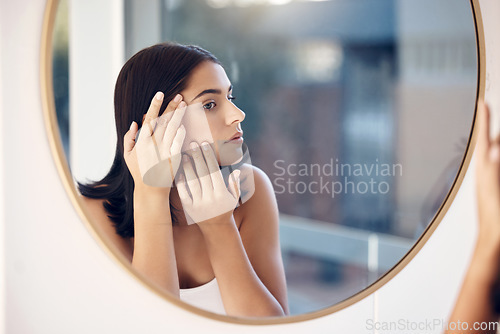 Image of Skincare, facial and woman by a mirror to check for acne breakout or pimples while cleaning face in bathroom. Beauty, wellness and healthy girl grooming or checking cosmetics results or prp progress