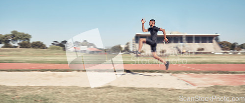 Image of Long jump, athletics and fitness with a sports man jumping into a sand pit during a competition event. Health, exercise and training with a male athlete training for competitive track and field