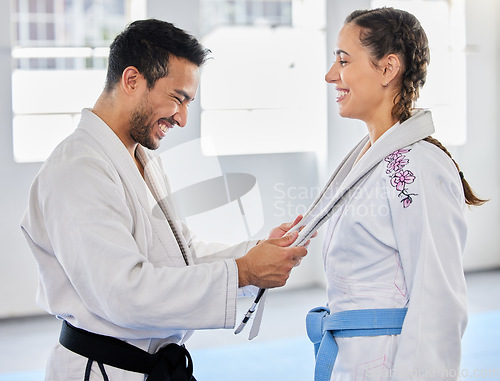 Image of Karate, belt and martial arts coach happy with fitness, workout and taekwondo student progress. Sports training achievement, ceremony and win of a woman after a fight exercise in a health gym studio