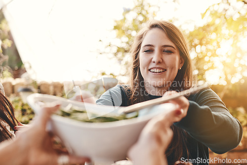 Image of Food, salad and healthy eating outdoor with woman giving or serving bowl with vegetables on patio for Christmas or thanksgiving lunch or dinner. Family or friends together to eat at home celebration