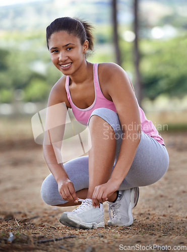 Image of Fitness, nature and woman tying her shoes before running in the forest for health, wellness and endurance. Sports, workout and portrait of a girl athlete preparing for a cardio exercise in the woods.