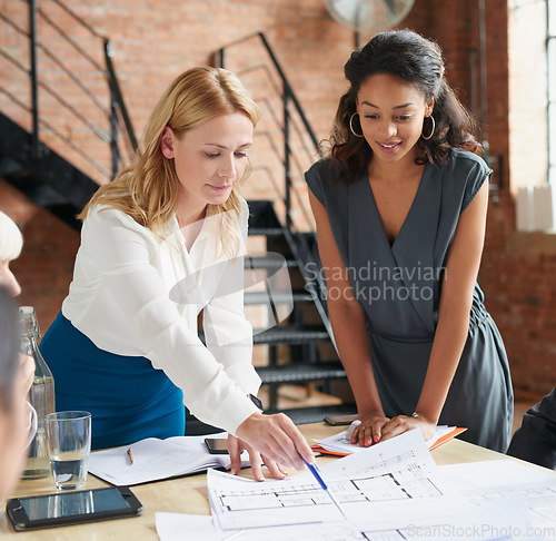 Image of Blueprint, architecture and women in meeting planning an office building construction with floor plan paperwork. Engineering, real estate or designers writing, pointing and talking about development