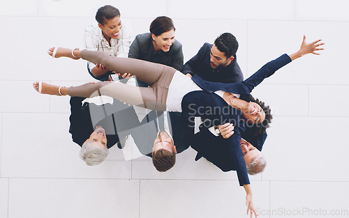 Image of Top view, business group and carrying woman with joy for successful deal and celebration in the office. Celebrate, success and businesspeople lifting a female staff member for cheering