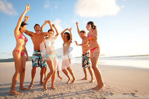 Image of Cheerful teenagers dancing on the beach. Portrait of happy teenagers dancing on the beach.