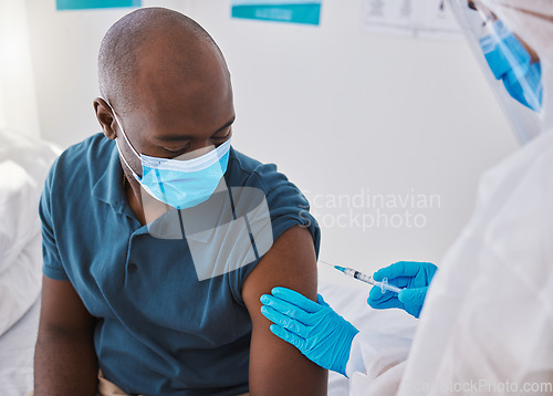 Image of Vaccine, injection and virus cure for covid, disease and pandemic illness from doctor, healthcare or medical professional. Male patient with mask being injected in arm by hazmat suit frontline worker