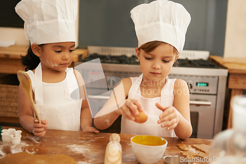 Image of Children bake in kitchen for learning and development of baker skill, fun with baking ingredients and chef hat with apron. Childhood, focus and girl kids making cookies, diversity and work together.