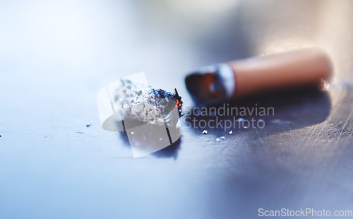 Image of Smoke, ash and burning cigarette butt on table, tobacco addiction awareness and prevention of risk of lung cancer, illness and danger of death. Stop smoking for better health, lifestyle and energy.