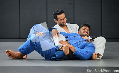 Image of Mma and karate with a teacher and student training and practicing in a gym with a gi choke. Combat sport, self defense and fighting while preparing for a fight or competition in a sports club